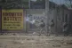 A police officer fires tear gas at people during a protest t