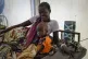 A mother sits with her malnourished baby at a hospital run b