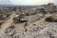 People inspect collapsed buildings following a devastating e