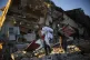 Residents remove their belongings from their destroyed house