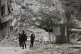 People stans by a building destroyed in recent earthquake in