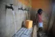 A resident without running water at home fills a container a