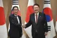 South Korean President Yoon Suk Yeol (right) shakes hands wi