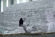 
 A worker walks next to a pile of sacks of food earmarked 