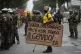 A protester holds a sign that reads in Portuguese: ‘Smile 