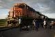 People watch a train go past as they wait along the train tr