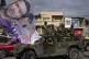 Soldiers stand guard on top of an armored vehicle as support