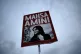 A woman holds a placard with a picture of Iranian woman Mahs