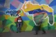 A man sells phone cables in front of a mural of the Venezuel