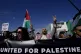 Demonstrators shout slogans and hold placards condemning Isr