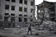 A local resident clears debris near a building damaged in th