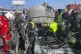 Civil Defense workers inspect the remains of a burned car th