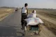 A Rohingya woman travels with a bag of rice that her family 