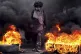 A protester protestor blocks a road, on the outskirts of Teg