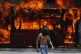 An anti-government protester walks near a bus that was set o