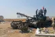 Syrian army soldiers flash the victory sign as they stand on
