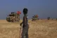 A Syrian boy looks on as Turkish conduct a joint ground patr