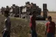 Local residents look on as a convoy of Turkish forces' truck