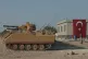 Turkish army personnel carriers are parked on a road towards