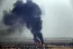 Flames and smoke billow from a fire on a target in Ras al-Ay