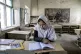A girl reads a book in her classroom on the first day of the