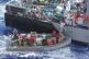 Distressed persons are transferred to a Maltese patrol vesse