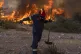 A firefighter leaves as the flames approaching him during a 