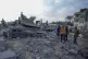Palestinians inspect the site of an Israeli strike in Deir A