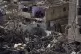 Palestinians look at the destruction after an Israeli strike