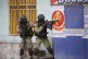 Police take cover during an anti-gang operation at Portail n