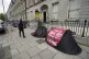 People walking past tents housing asylum seekers near to the
