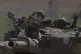 Israeli soldiers move on the top of a tank near the Israeli-