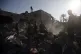 Palestinians inspect the damage of a destroyed house followi