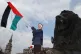 A young supporter of Palestine waves a flag next to one of t
