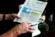 An elderly lady holding a British Gas bill at home in Liverp