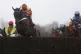 Horses and their riders volt a hedge at Kempton race course
