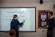 A teacher invites a student to write an answer onto a whiteb