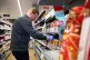A shop worker stacks shelves whilst wearing PPE at a Co-op s
