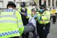 A protester is removed by police officers during an Extincti