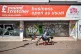 A man on a mobility scooter moves past closed shop shutters 