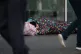 People walk past a homeless man in London