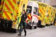 A paramedic is seen with a row of ambulances outside the Roy