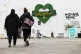 Two women walk towards the Grenfell Memorial Wall in the gro
