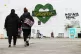 Two women walk towards the Grenfell Memorial Wall in the gro