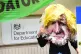A person wearing a Boris Johnson paper mache mask takes part