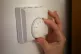 A person using a central heating thermostat