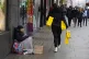 Christmas shoppers on Oxford Street, London, pass a homeless