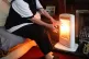 An elderly lady with her electric fire on at home