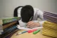 A primary school teacher next to piles of classroom book