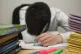 A primary school teacher next to piles of classroom books